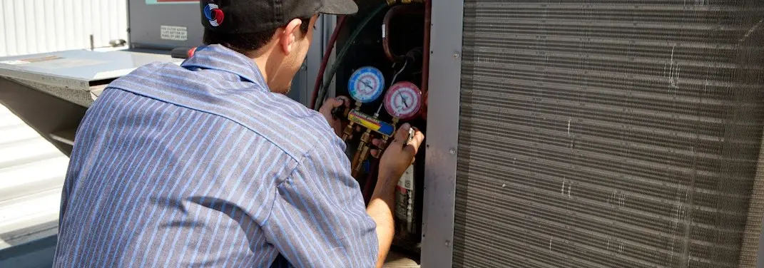 HVAC technician servicing a condenser unit in Chelmsford